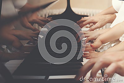 Family of three members playing a piano together Stock Photo