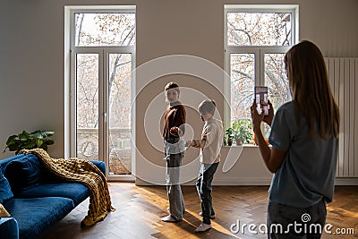 Family of three mother and two kids making social media content video on smartphone Stock Photo