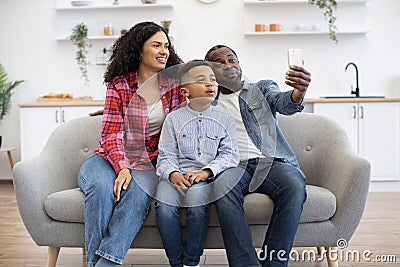 Family of three taking video call via mobile at home Stock Photo