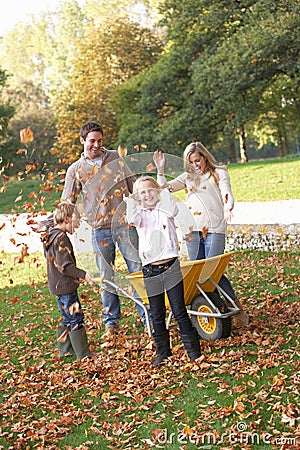 Family throwing autumn leaves into the air Stock Photo