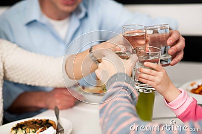 Family toasting water glasses in celebration Stock Photo