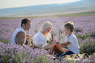 Happy family in a field of lavender on sunset. Stock Photo