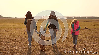 Family travels with the dog across the plains and mountains. mother, daughters and home pets tourists. teamwork of a Stock Photo