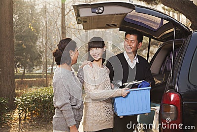 Family unpacking minivan for college, Beijing Stock Photo