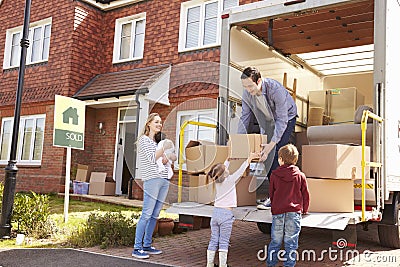 Family Unpacking Moving In Boxes From Removal Truck Stock Photo