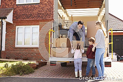 Family Unpacking Moving In Boxes From Removal Truck Stock Photo