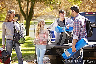 Family Unpacking Pick Up Truck On Camping Holiday Stock Photo