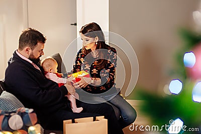 Family unwrapping Christmas present on sofa Stock Photo