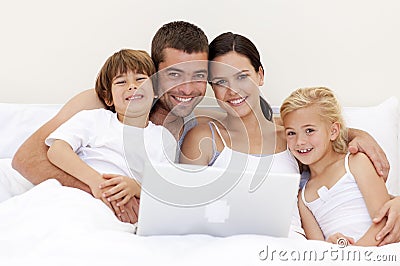 Family using a laptop in bed Stock Photo