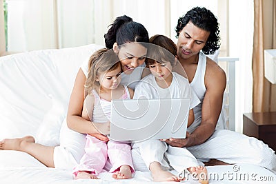 Family using a laptop on the bed Stock Photo