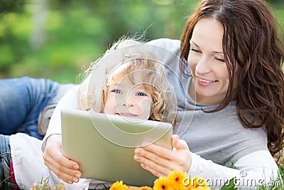 Family using tablet PC outdoors Stock Photo