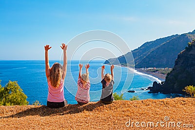 Happy mother, kids on hill with sea cliffs scenic view Stock Photo