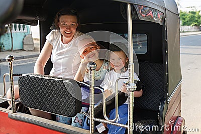 Family on vacation, mother and kids sitting in tuk-tuk, having fun Stock Photo