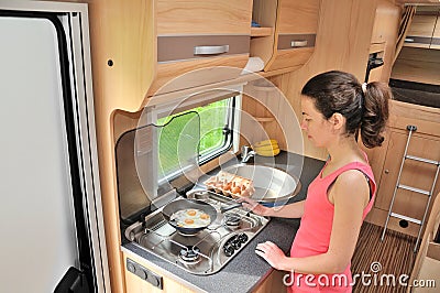 Family vacation, RV holiday trip, travel and camping, woman cooking in camper, motorhome interior Stock Photo