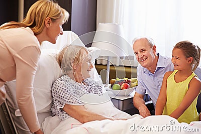 Family Visit To Grandmother In Hospital Bed Stock Photo