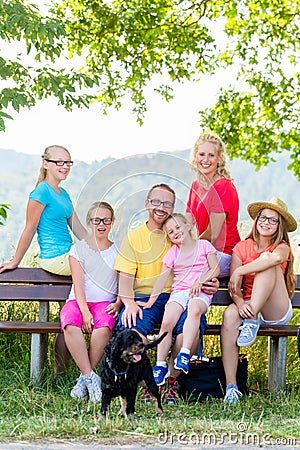 Family on walk having rest on bench Stock Photo