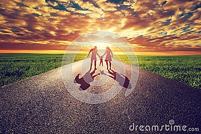 Family walk on long straight road, way towards sunset sun Stock Photo