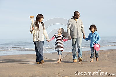 Family Walking By Sea On Winter Beach Stock Photo