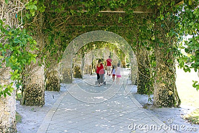 A Family Walking down a Whimsical Stone Trellis Path Editorial Stock Photo