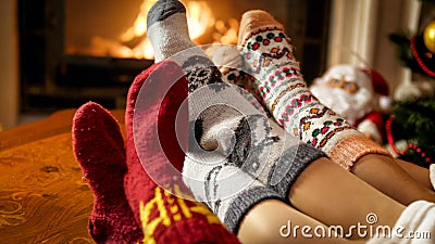 Family in warm woolen socks warming by the fireside at house Stock Photo