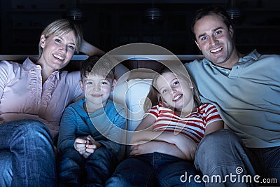 Family Watching TV On Sofa Together Stock Photo