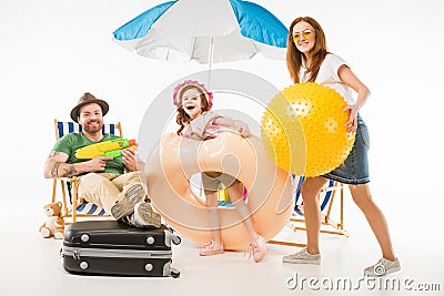 Family with water gun, flotation ring and ball Stock Photo