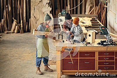 Family working together in woodwork workshop Stock Photo