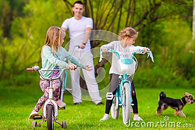 Family of young father and little kids biking at Stock Photo