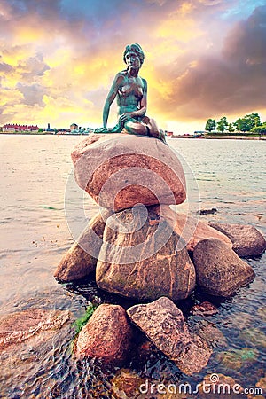 Famous bronze sculpture of a melancholy little mermaid on the waterfront - symbol of Copenhagen, Denmark. Exotic amazing places. Editorial Stock Photo
