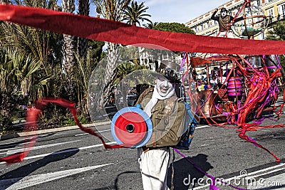 Famous Carnival of Nice, Flowers` battle. Male Entertainer in carnival Costume launches colored ribbons Editorial Stock Photo