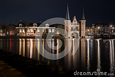 The famous historical `Waterpoort` in the city of Sneek at night with reflections in the canal - Sneek, Friesland, The Netherlan Editorial Stock Photo