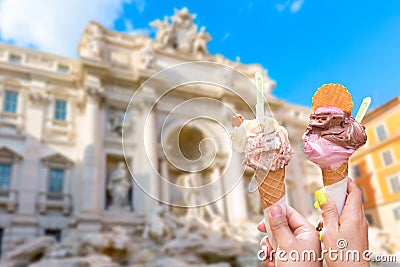 Famous landmark fountain di Trevi in Rome, Italy during summer sunny day with italian ice cream gelato in the foreground Stock Photo