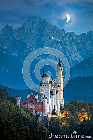 Famous Neuschwanstein Castle at night with moon and illumination Stock Photo