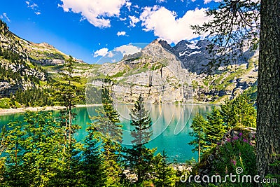 Famous Oeschinensee with Bluemlisalp mountain on a sunny summer day. Panorama of the azure lake Oeschinensee. Swiss alps, Stock Photo