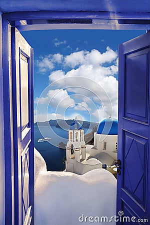 Santorini view with churches against blue door in Oia village, Greece Stock Photo