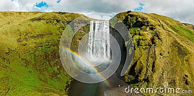 Famous Skogafoss waterfall with a rainbow. Dramatic Scenery of Iceland during sunset. Stock Photo