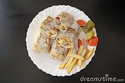 Arabic chicken shawarma plate with fried fries and pickled vegetables on dark wooden background, top view. Shawarma wrap on white Stock Photo