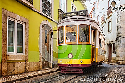 Famous vintage yellow tram 28 in the narrow streets of Alfama district in Lisbon, Portugal Editorial Stock Photo