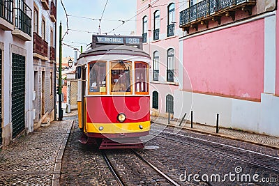 Famous vintage yellow tram 28 in the narrow streets of Alfama district in Lisbon, Portugal Editorial Stock Photo