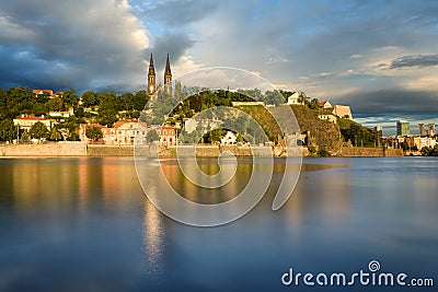 Famous Vysehrad church during sunny day. Amazing cloudy sky in motion. Vltava river, Prague, Czech republic Stock Photo