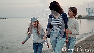 A família caminha pela costa no pôr do sol uma jovem mãe se diverte com seus filhos vídeos de arquivo A família caminha pela costa no pôr do sol uma jovem mãe se diverte com seus filhos vídeos de arquivo