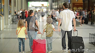 A família feliz com a menina e o menino que vão na estação de trem, o pai da mãe e as crianças andam através do aeroporto com video estoque A família feliz com a menina e o menino que vão na estação de trem, o pai da mãe e as crianças andam através do aeroporto com video estoque