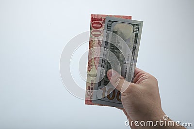 Fan of money dollar and riyals in male hands isolated on white. Stock Photo