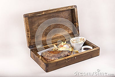 Fancy dish with grilled pork ribs, barbecue sauce, French fries, Coleslaw salad, in a wooden box Stock Photo