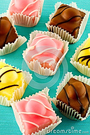 Eight iced fancy fondant cakes. Stock Photo