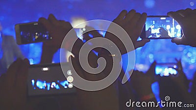 Fans hands recording video and taking pictures with smart phones at music concert. People crowd partying at rock concert Stock Photo