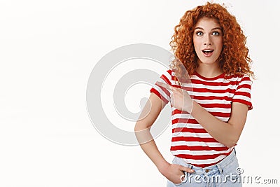 Fantastic deal check out. Amused good-looking redhead curly stylish girl wearing striped t-shirt discuss awesome promo Stock Photo