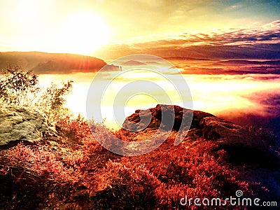 Fantastic dreamy sunset on top of rocky mountain with view into evening autumnal valley Stock Photo