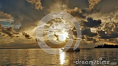 Fantastic golden sunset in the Maldives.The setting sun shines through the picturesque clouds Stock Photo
