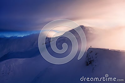 Fantastic scenery with a free rider and mountaineer, high mountains in snow and the fog with interesting colour. Stock Photo